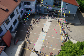 Kinder lassen Luftballons steigen im Pausenhof der Dominikus Savio Schule Ebern